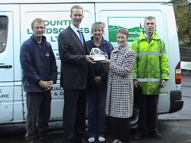 Yvonne Lyon of ChamberLink presenting the Investor in People Plaque to Lee Thorne MD with (from the right) James Taylor - Apprentice Landscaper Gardener Anita Martin - Operations Supervisor, and Craig Goldsworthy - Foreman